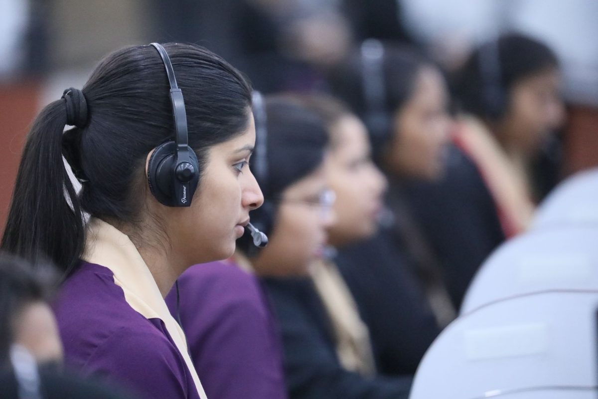 Support agent with a headset taking a customer call at a busy support centre